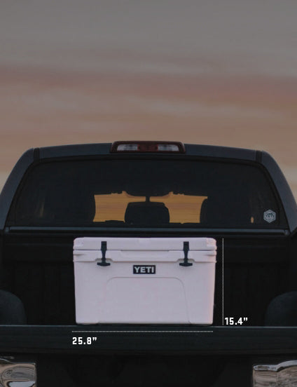 White YETI cooler in a truck bed with sunset reflection