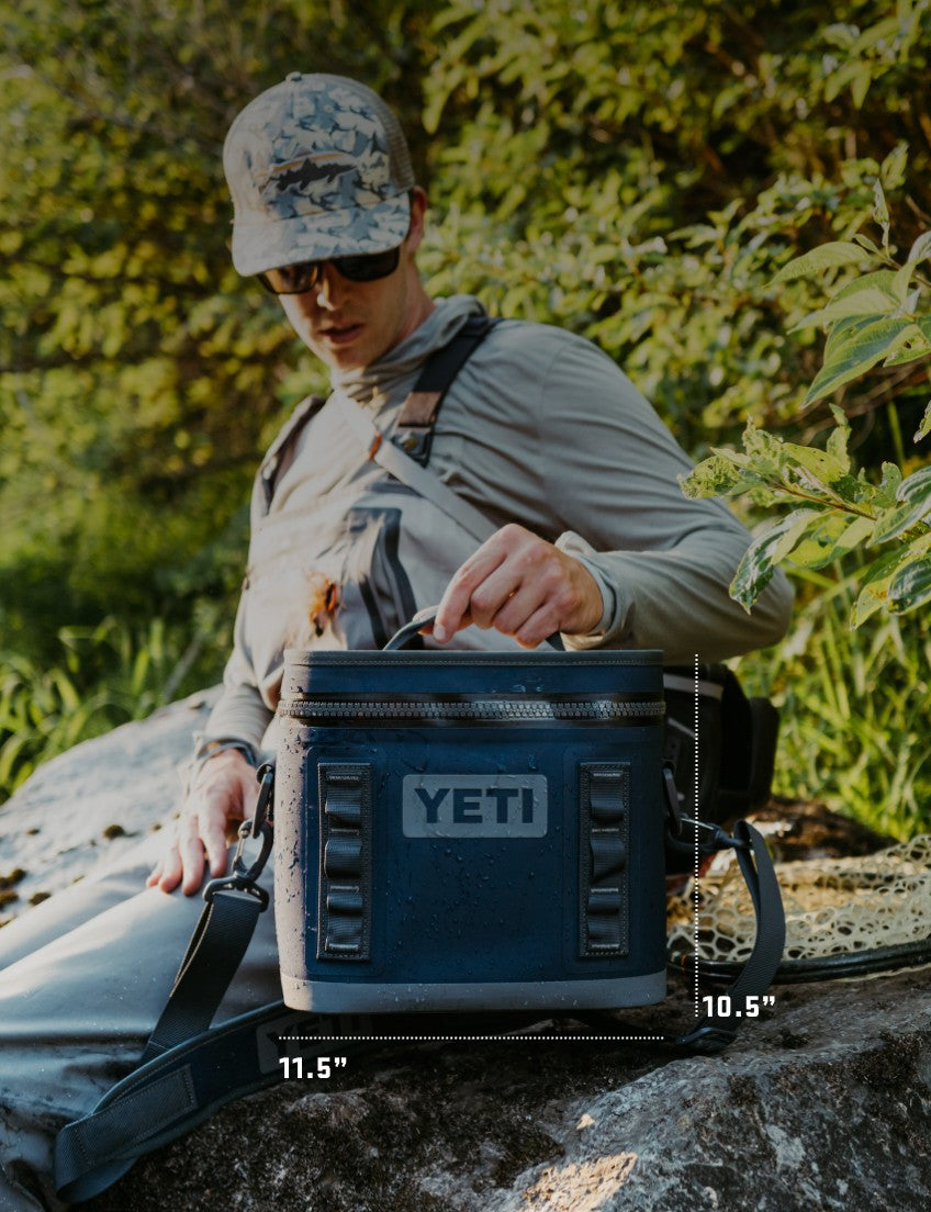 Person sitting outdoors with a YETI cooler
