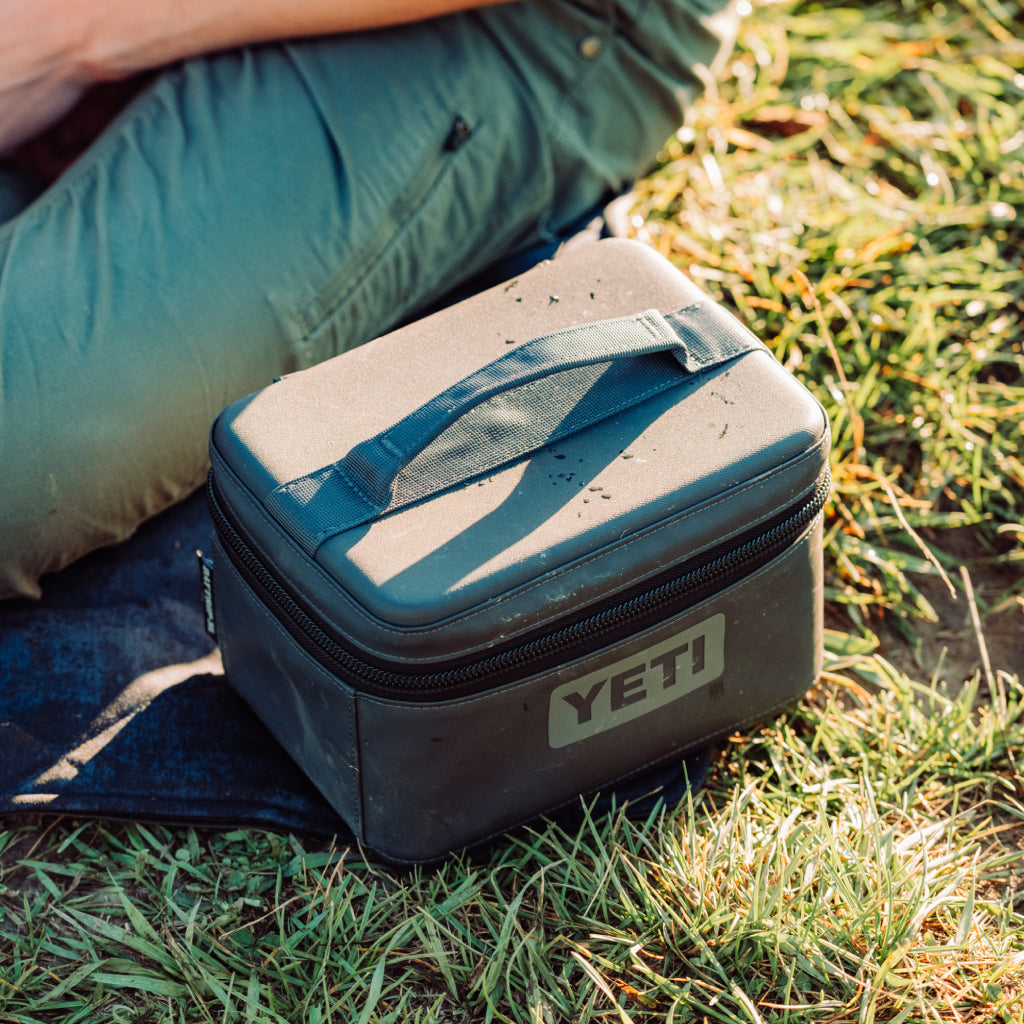 YETI cooler bag on grass with person partially visible