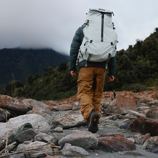 Person hiking on a rocky trail with a large backpack