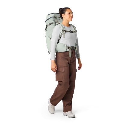 Person wearing a large backpack and brown pants on a white background
