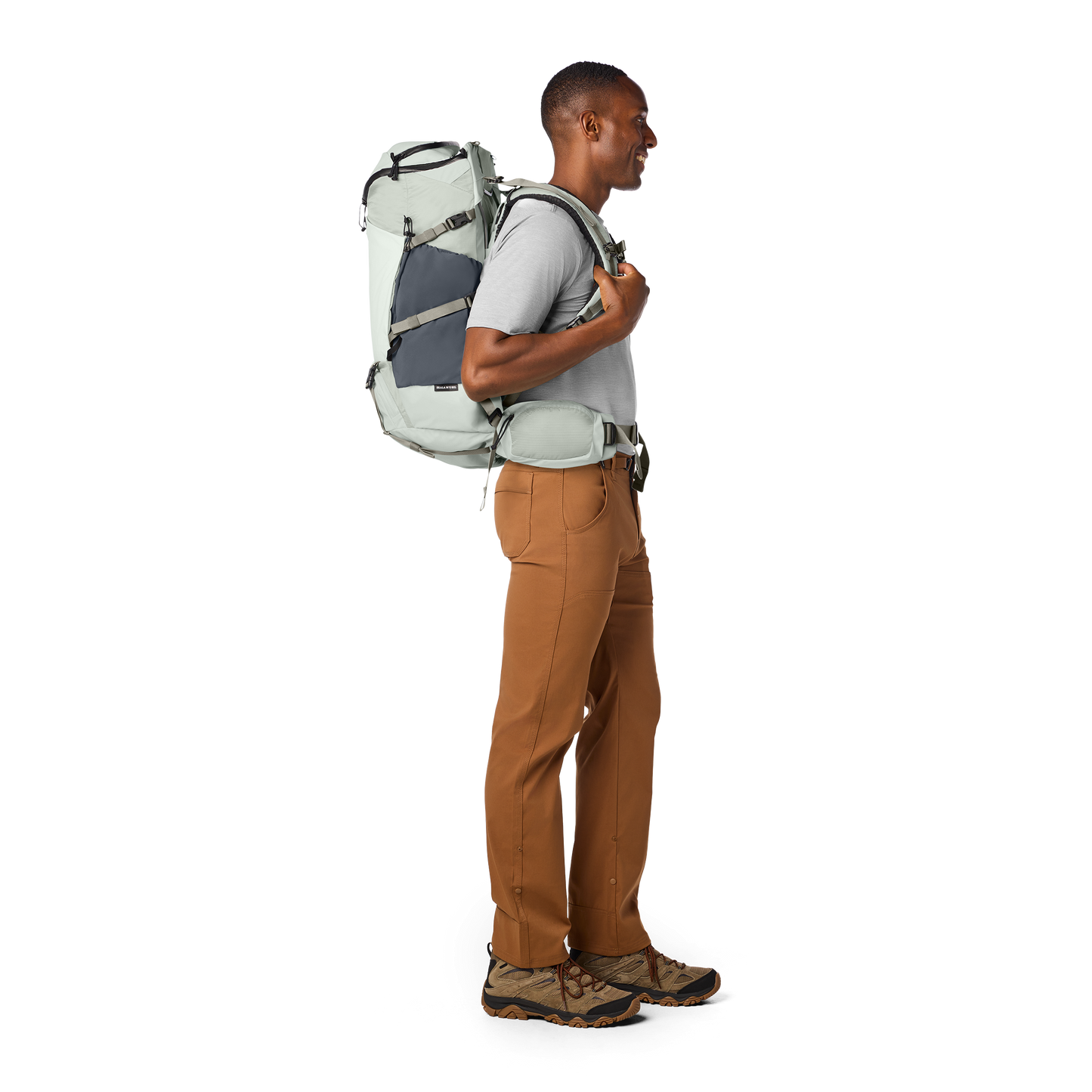 Man wearing a large backpack on a white background