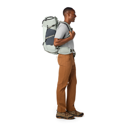 Man wearing a large backpack on a white background